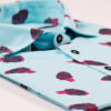 Camisa estampada, de hombre, de manga corta, hecha en algodón orgánico, con estampado de corazones sobre fondo turquesa.