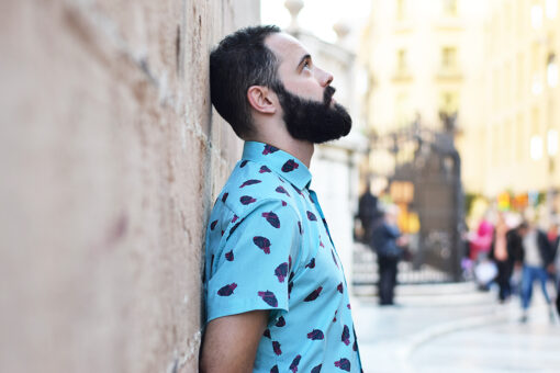 Camisa estampada, de hombre, de manga corta, hecha en algodón orgánico, con estampado de corazones sobre fondo turquesa.