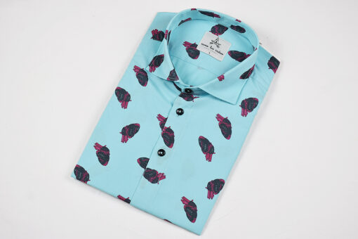 Camisa estampada, de hombre, de manga corta, hecha en algodón orgánico, con estampado de corazones sobre fondo turquesa.