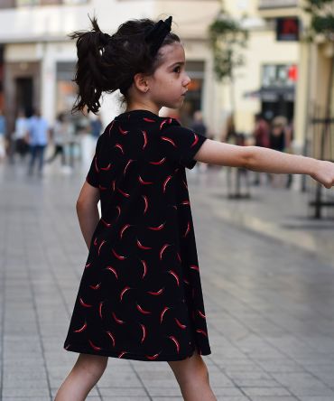 Vestido infantil Chili, hecho en algodón orgánico, de manga corta, con estampado de chilis sobre fondo negro. Hecho en España.