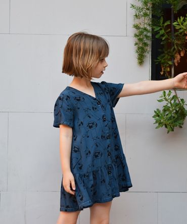 Vestido infantil Acróbatas, hecho en viscosa, de manga corta, con estampado de acróbatas sobre fondo azul. Hecho en España.
