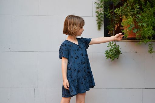 Vestido infantil Acróbatas, hecho en viscosa, de manga corta, con estampado de acróbatas sobre fondo azul. Hecho en España.