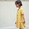 Vestido infantil Moscas, hecho en viscosa, de manga corta, con estampado de moscas y rayas amarillas. Hecho en España de manera sostenible.