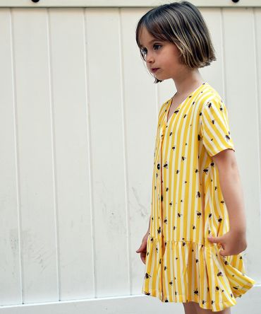Vestido infantil Moscas, hecho en viscosa, de manga corta, con estampado de moscas y rayas amarillas. Hecho en España de manera sostenible.