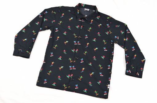 Camisa infantil hecha en algodón orgánico con bonito estampado de esquiadores sobre fondo negro. Es de manga larga y bajo recto.