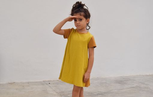 Vestido infantil Curry, hecho en algodón orgánico, de manga corta, combina color curry en el delantero y color ocre en mangas y trasero. Hecho en España.