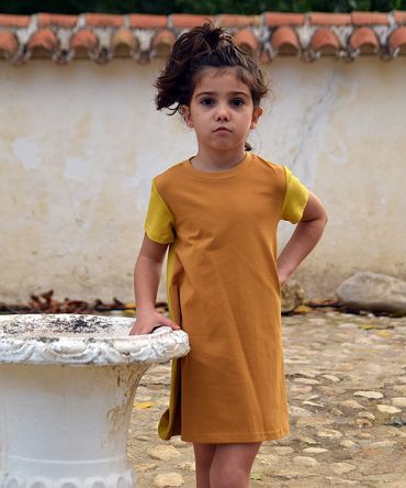 Vestido infantil Ocre, hecho en algodón orgánico, de manga corta, combina color ocre en el delantero y color curry en mangas y trasero. Hecho en España.
