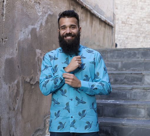 Camisa estampada de hombre, de manga larga, hecha en algodón orgánico, con estampado de grullas sobre fondo turquesa. Es una camisa hecha en España de manera sostenible.