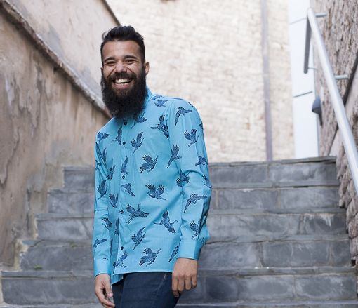 Camisa estampada de hombre, de manga larga, hecha en algodón orgánico, con estampado de grullas sobre fondo turquesa. Es una camisa hecha en España de manera sostenible.