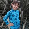 Camisa infantil estampada, de manga larga. Camisa de niño hecha en algodón orgánico con estampado de grullas sobre fondo turquesa. Es una prenda sostenible hecha en España.