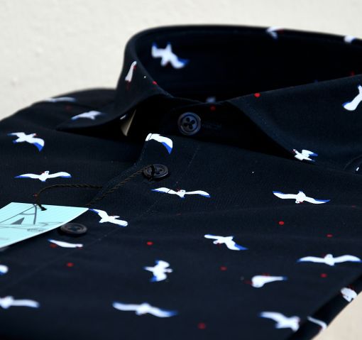 Camisa estampada de hombre, de manga corta, hecha en algodón orgánico, con estampado de gaviotas sobre fondo negro.