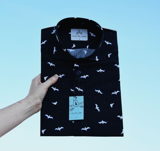 Camisa estampada de hombre, de manga corta, hecha en algodón orgánico, con estampado de gaviotas sobre fondo negro.