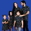 Conjunto de vestidos y camisas de adulto y niños con estampado de comecocos sobre fondo negro para que las familias puedan vestir iguales.