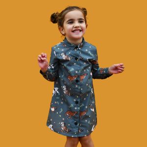 Vestido camisero de niña, de manga larga, hecho en algodón orgánico con estampado de perretes sobre fondo verde militar. Hecho en España.