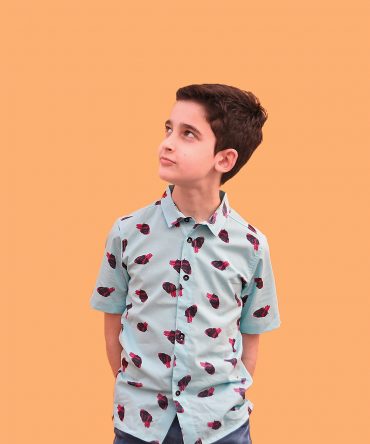Camisa infantil hecha en algodón orgánico con bonito estampado de corazones sobre fondo turquesa. Es de manga corta y bajo recto.