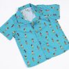 Camisa de niño estampada con chicas hula sobre fondo turquesa. Es de manga corta y está hecha en algodón orgánico, de manera sostenible.